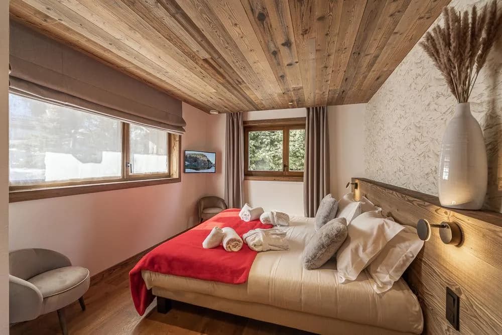 Double bedroom with red bedspread and timber ceiling