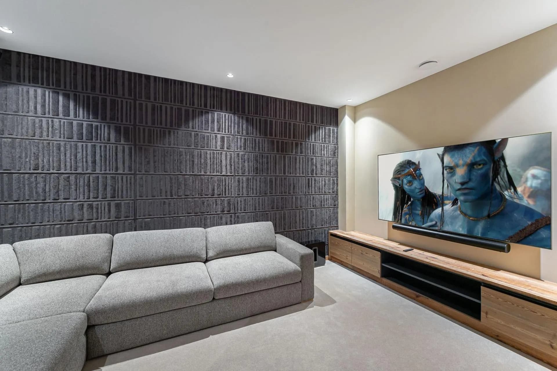Cinema room with wall-mounted screen, soundbar and acoustic panelling