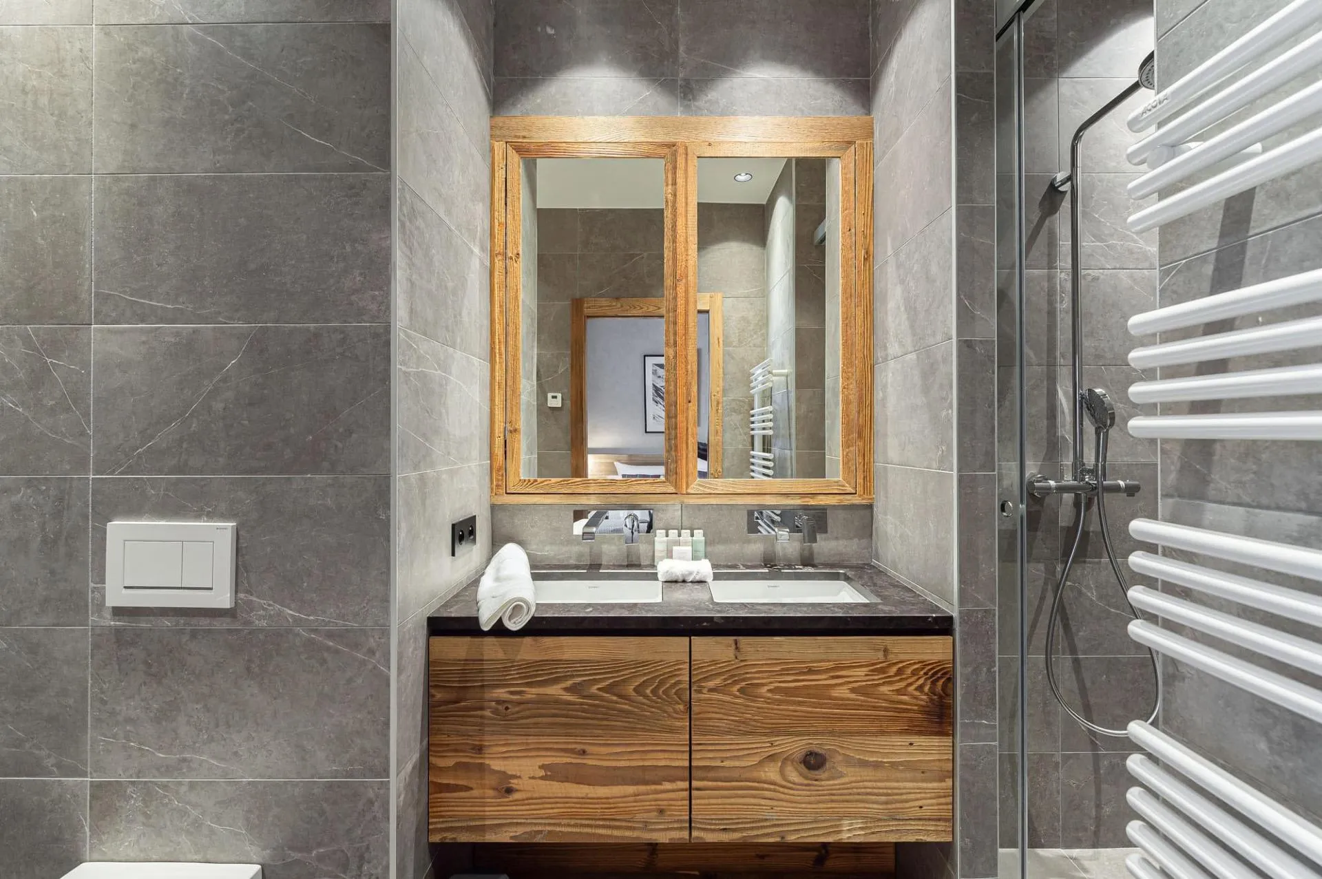 En-suite shower room with twin basins, heated towel rail and walk-in shower