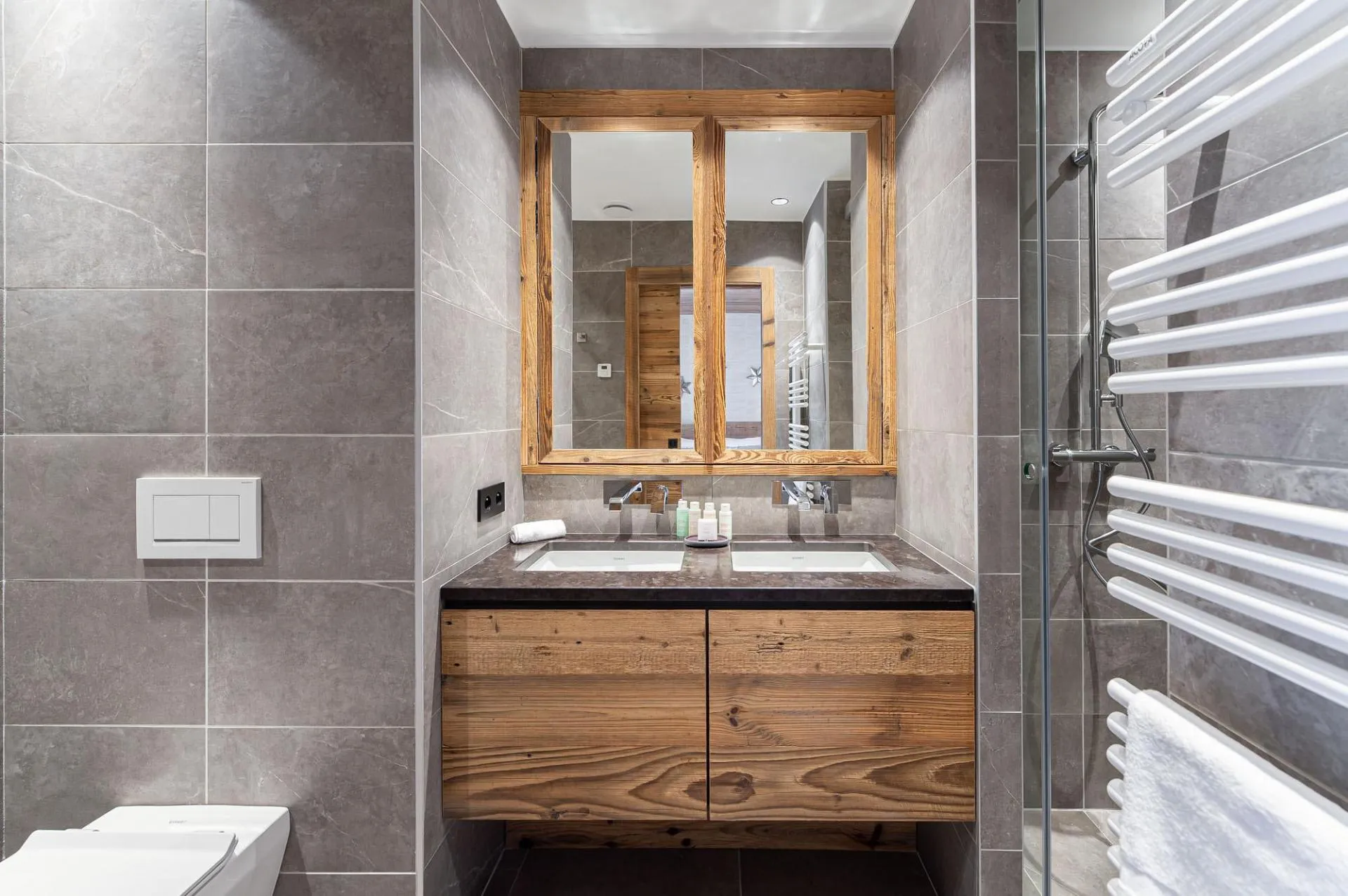 En-suite shower room with twin basins, heated towel rail and walk-in shower