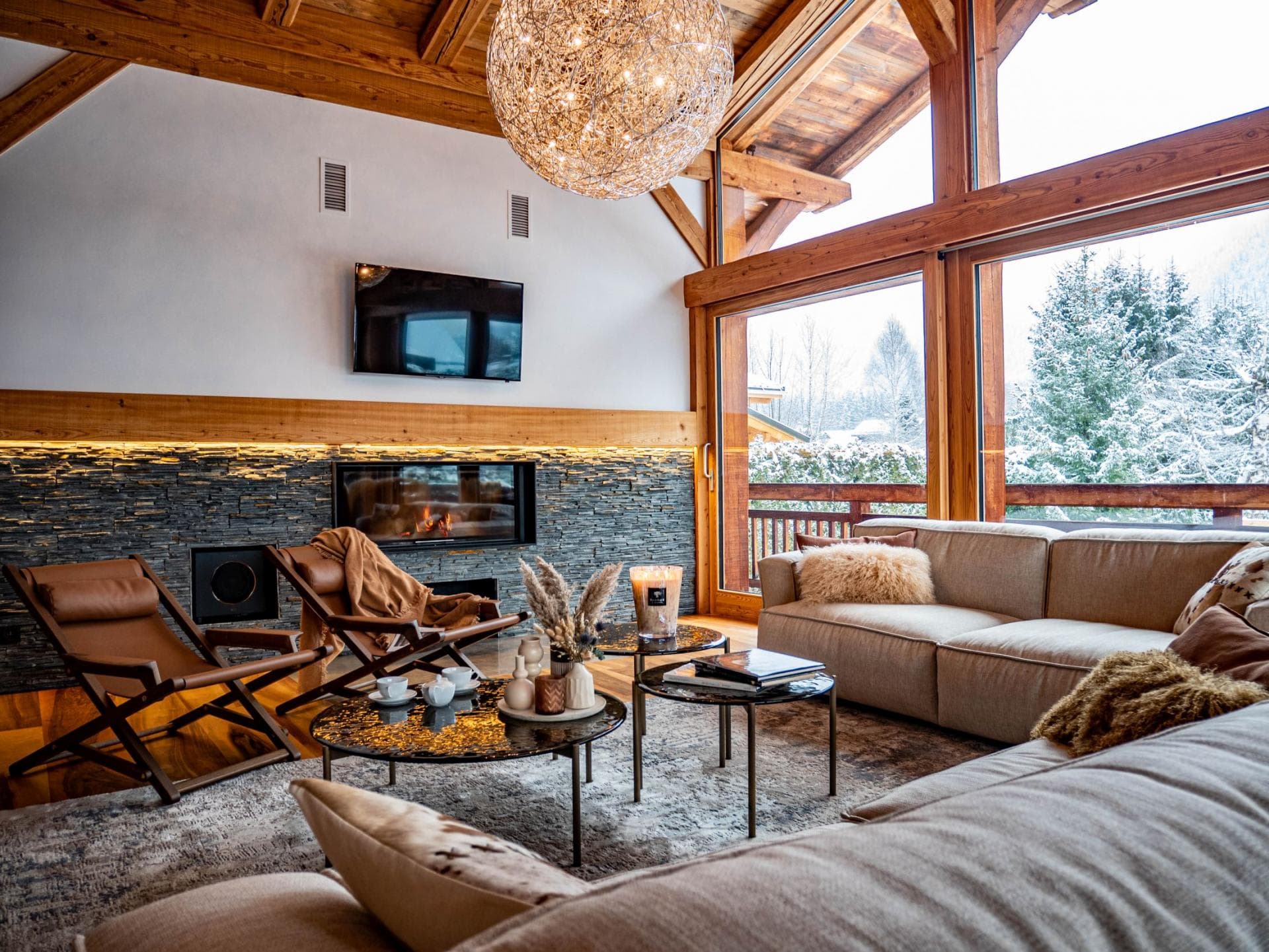 Living area with gas fireplace and floor-to-ceiling windows showing snowy mountain views