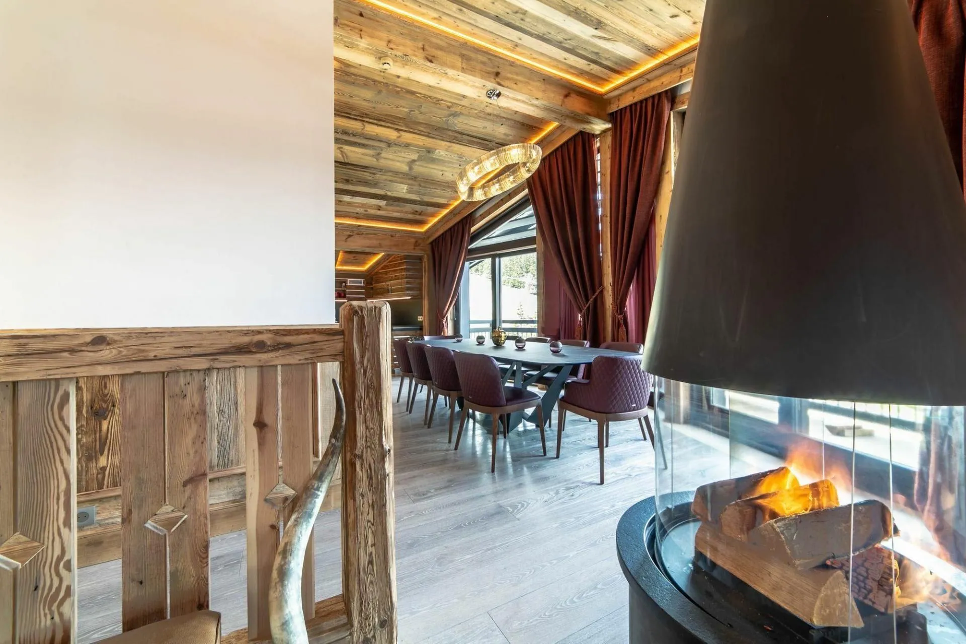Dining area beside the suspended fireplace and bay windows