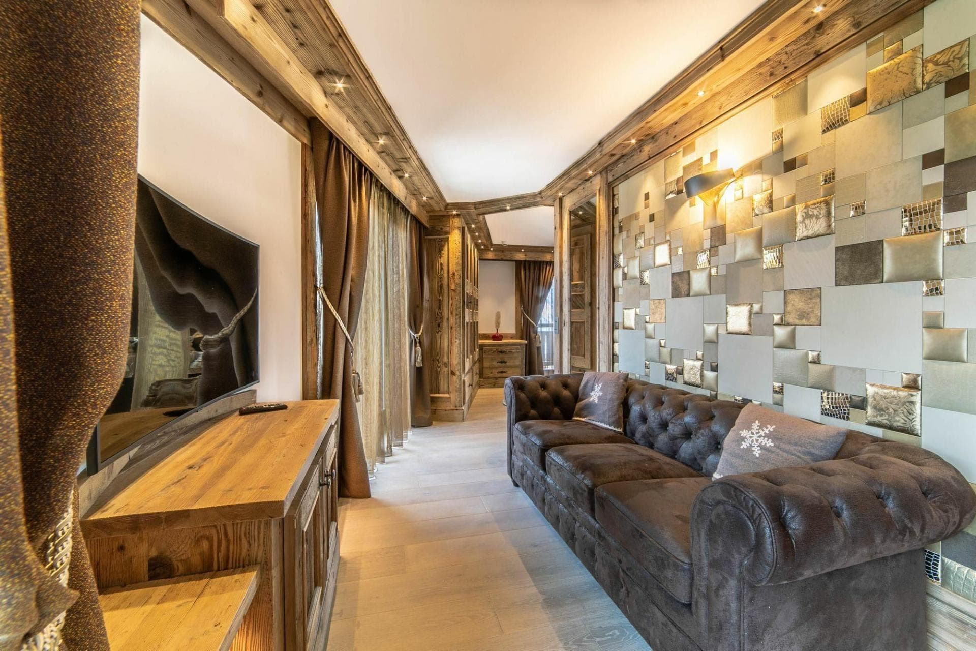Living area with tufted leather sofa and integrated ceiling lighting