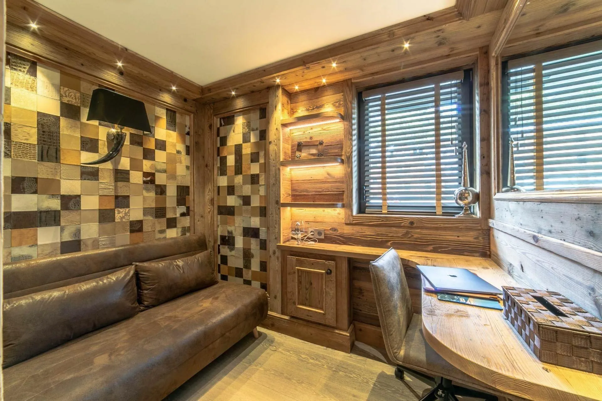 Office with desk, upholstered sofa and timber walls
