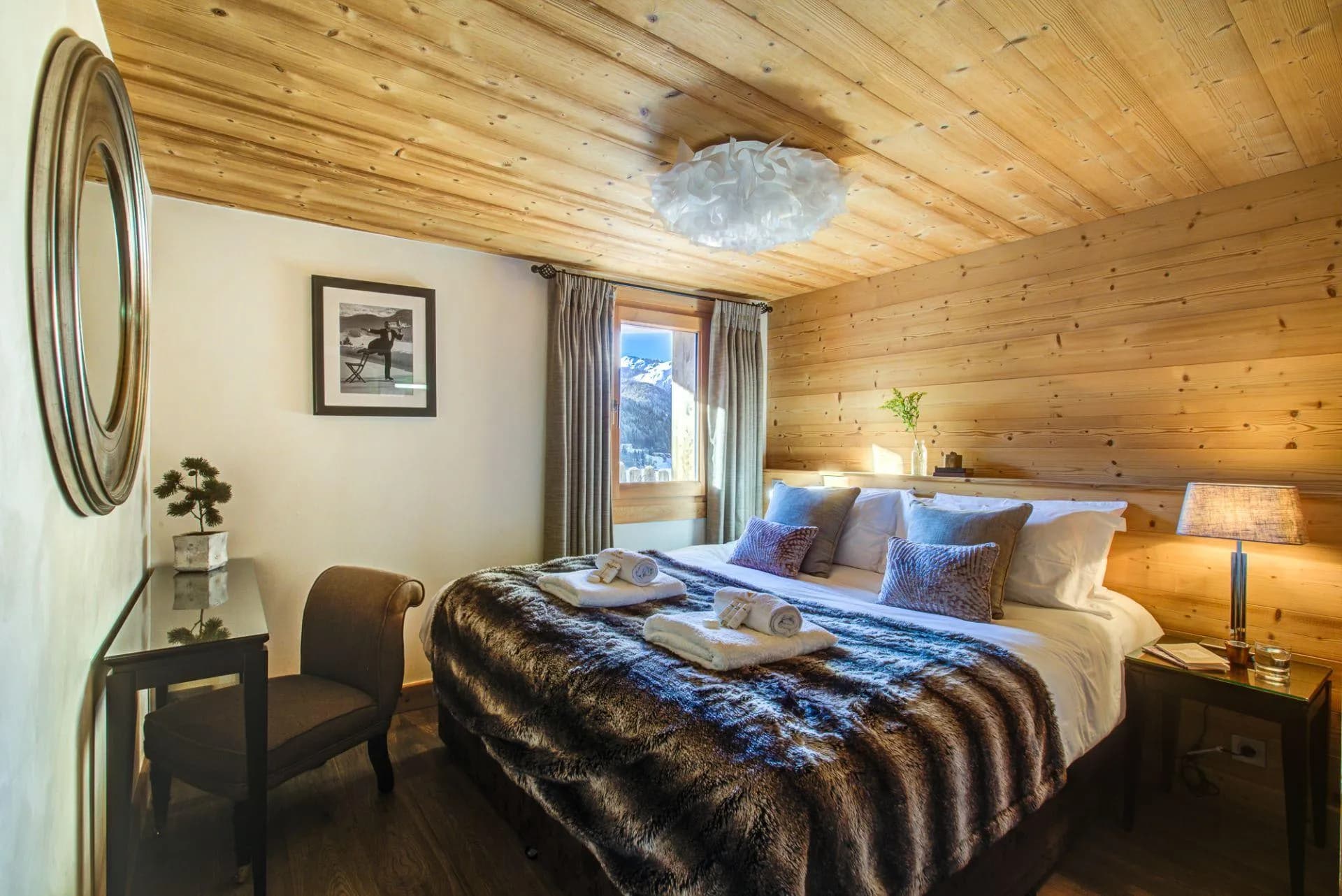 Wood-panelled bedroom arranged as a double with mountain views
