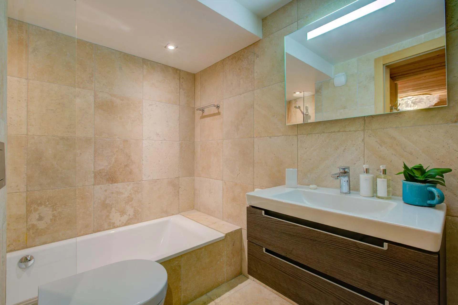 Bathroom with bath and floor-to-ceiling stone tiles