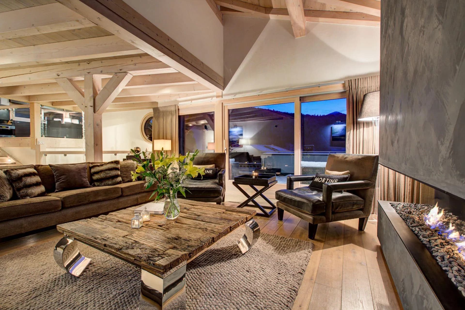 Double-height living area with modern fireplace and vaulted timber ceiling