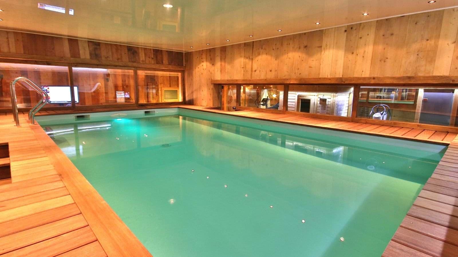 Indoor heated pool with wood decking and views into the sauna area