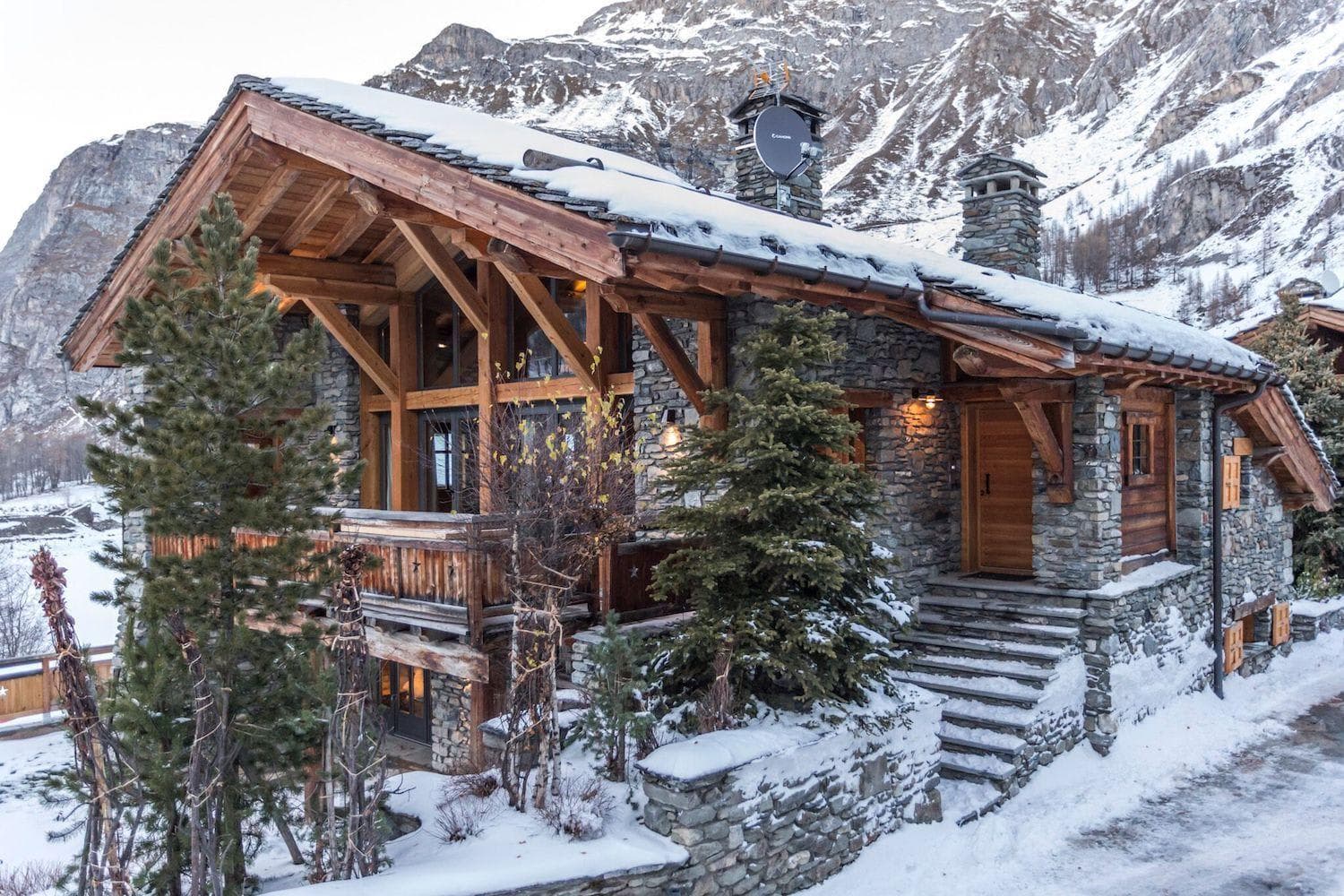 Stone and timber chalet exterior with mountain backdrop and private balcony