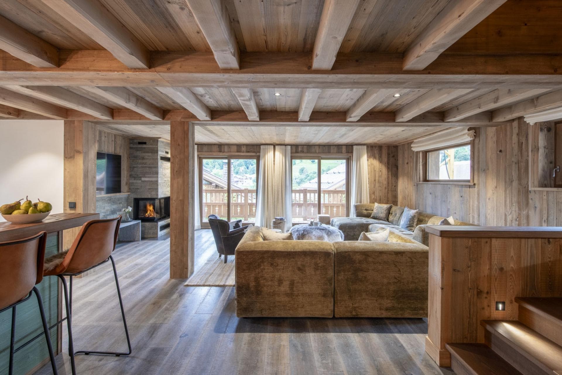 Living area with wood-burning fireplace, sectional seating, and balcony access
