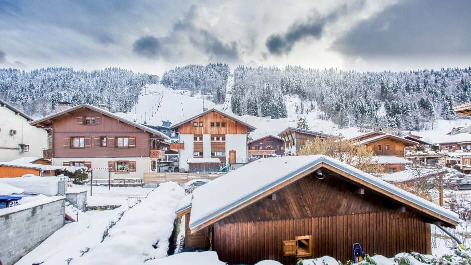 Chalet exterior with ski lift and mountain runs in background