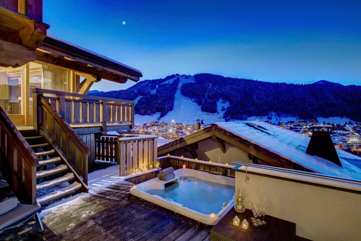 Sunken deck hot tub with views of illuminated ski slopes