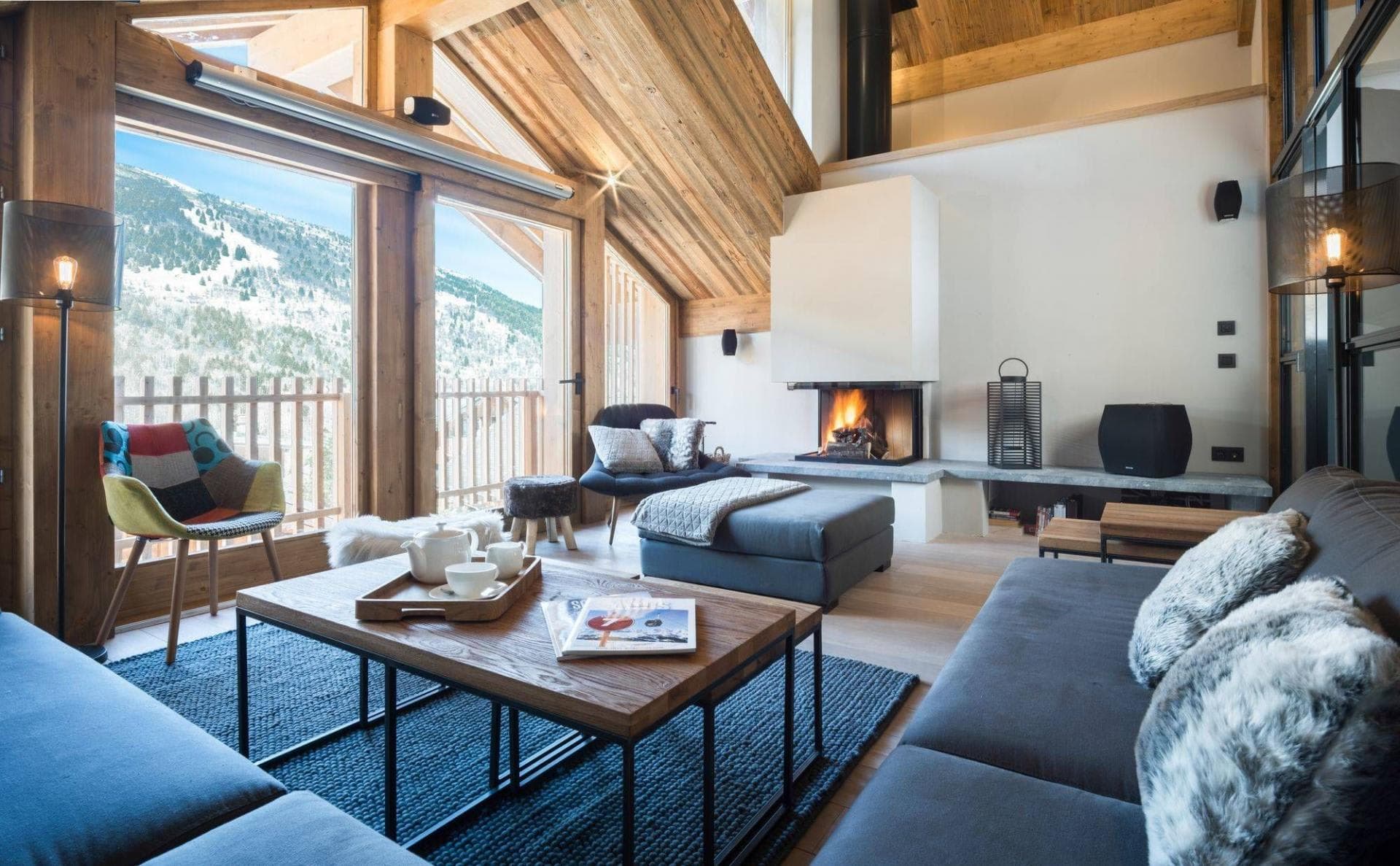 Living area with wood-burning fireplace and mountain-view balcony access