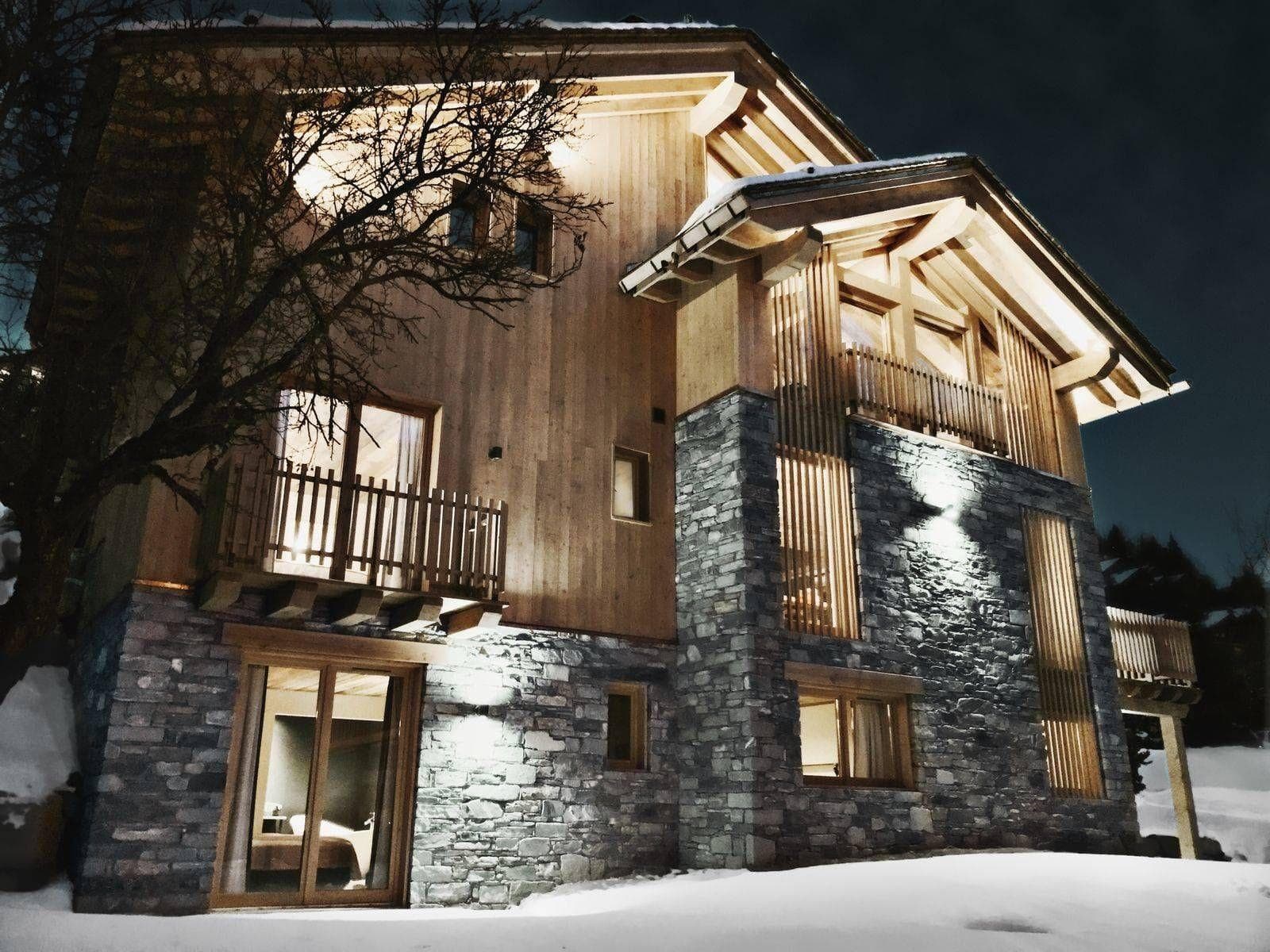 Chalet exterior featuring stone masonry, timber cladding, and private balconies