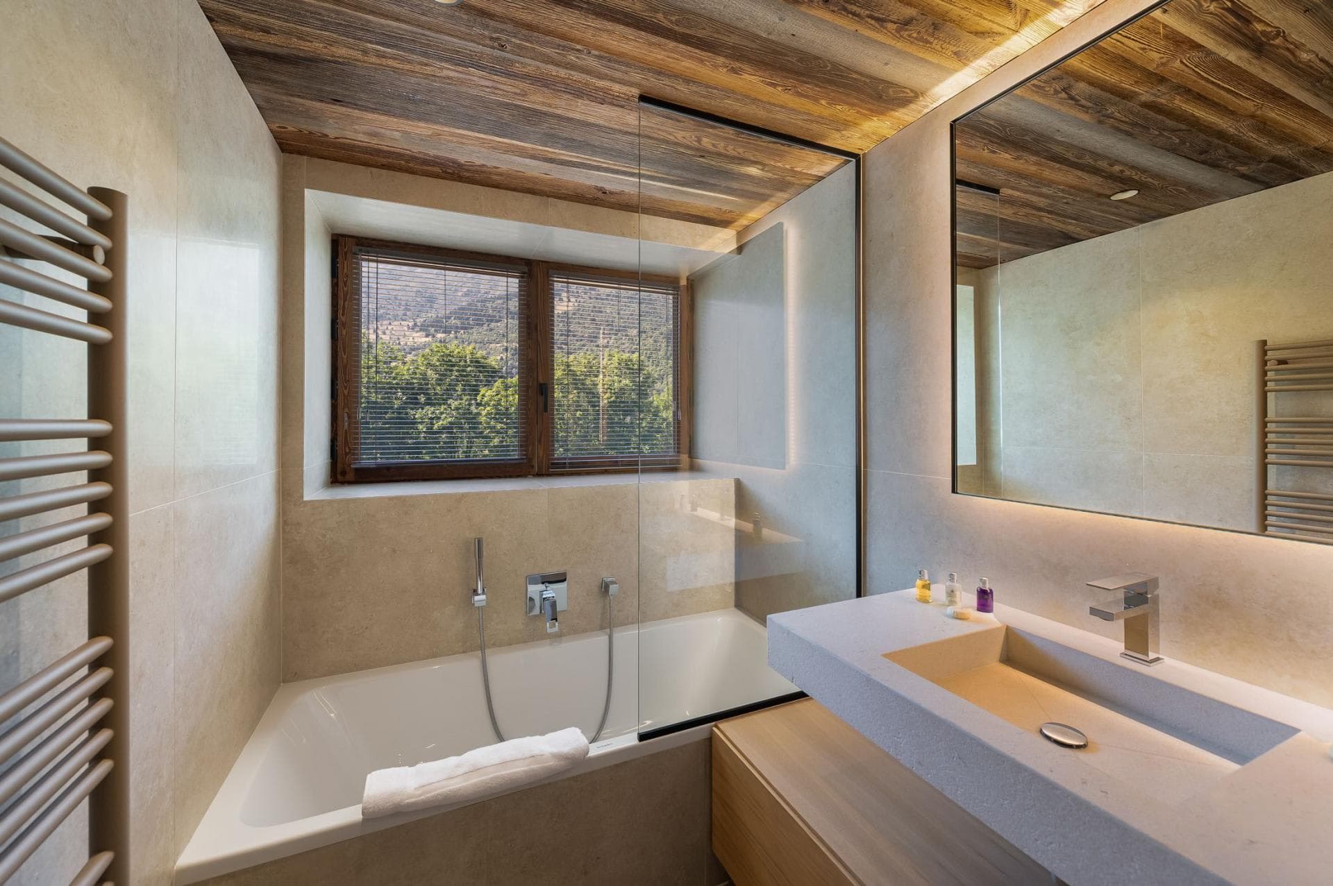 Bathroom featuring soaking tub with handheld sprayer and heated towel rack