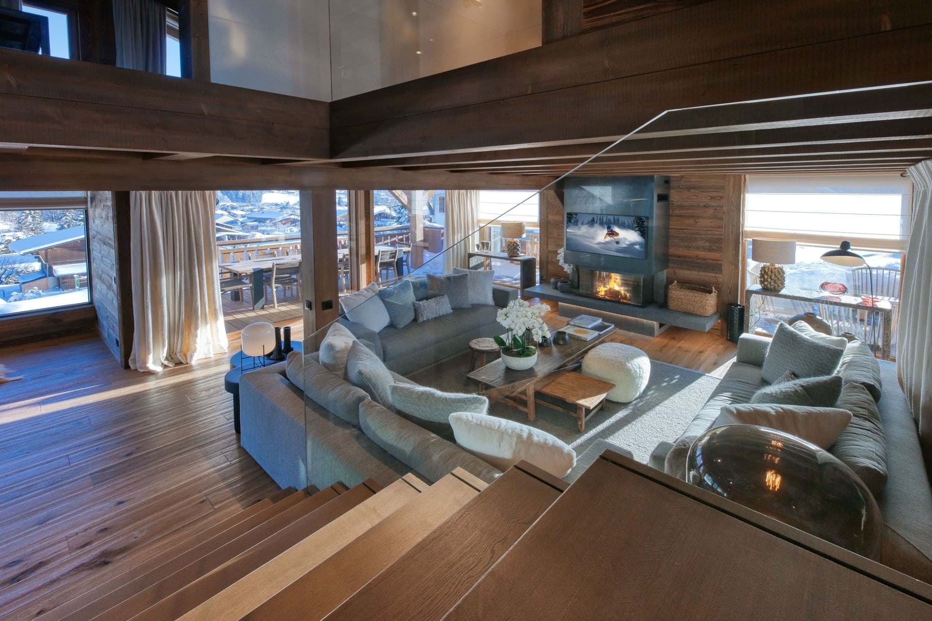 Great room with two-story ceilings, fireplace, and wraparound lake views from multiple windows