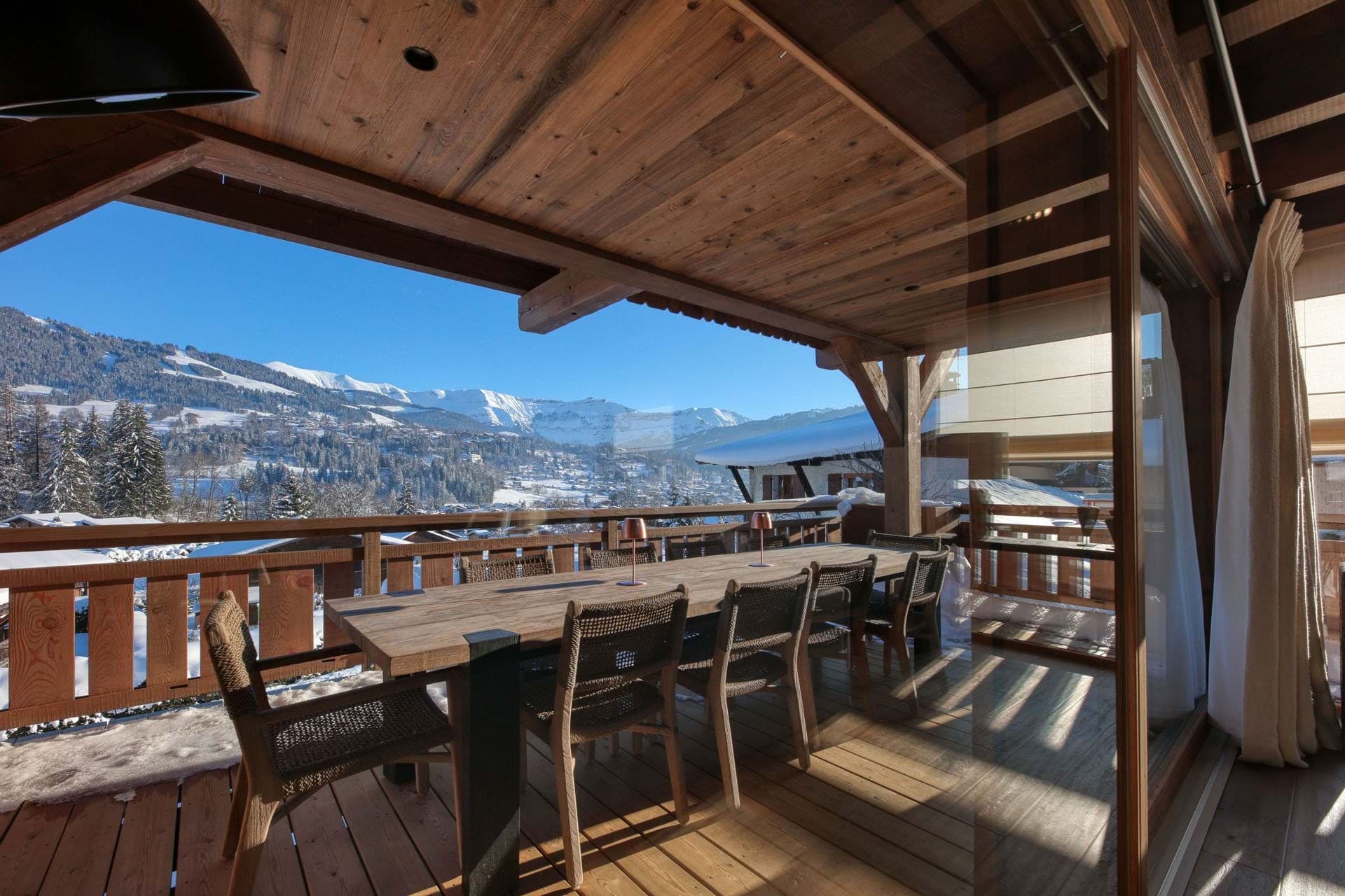 Covered deck with dining table seating 6; snow-capped mountain and valley views