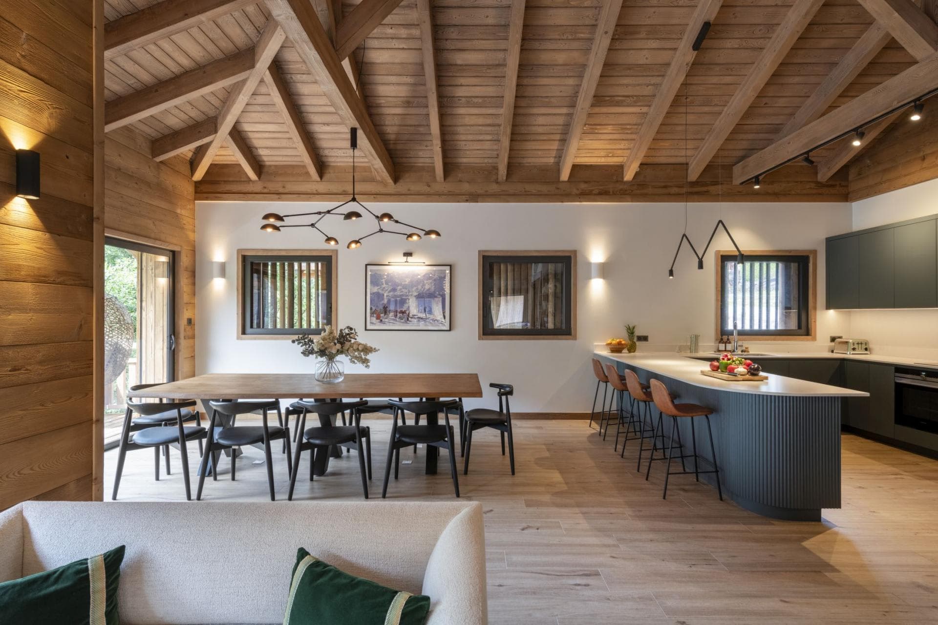 Open-plan dining and kitchen area; table seats 8 with 4 island stools