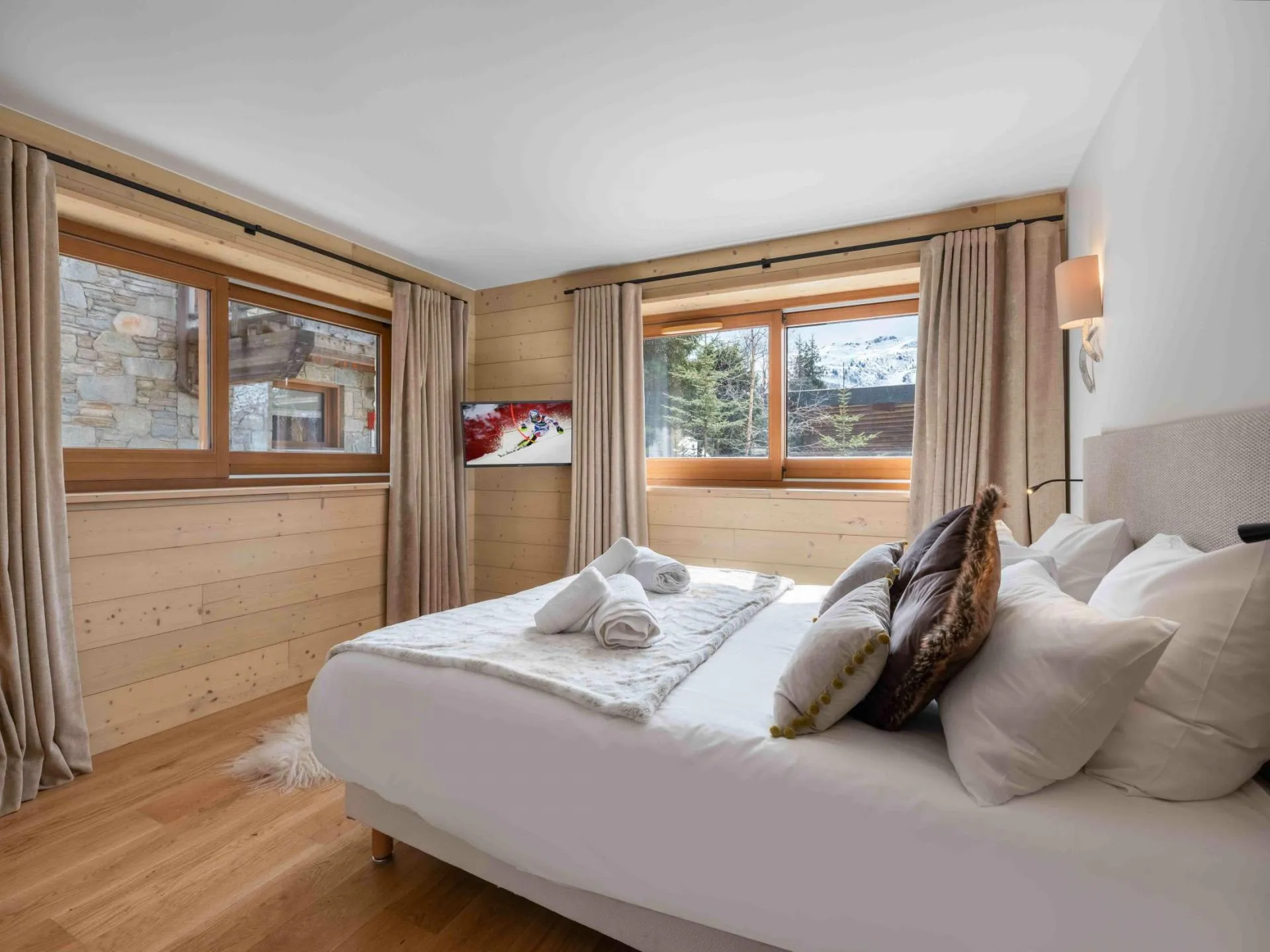 Double or twin bedroom with a wall-mounted TV and mountain views