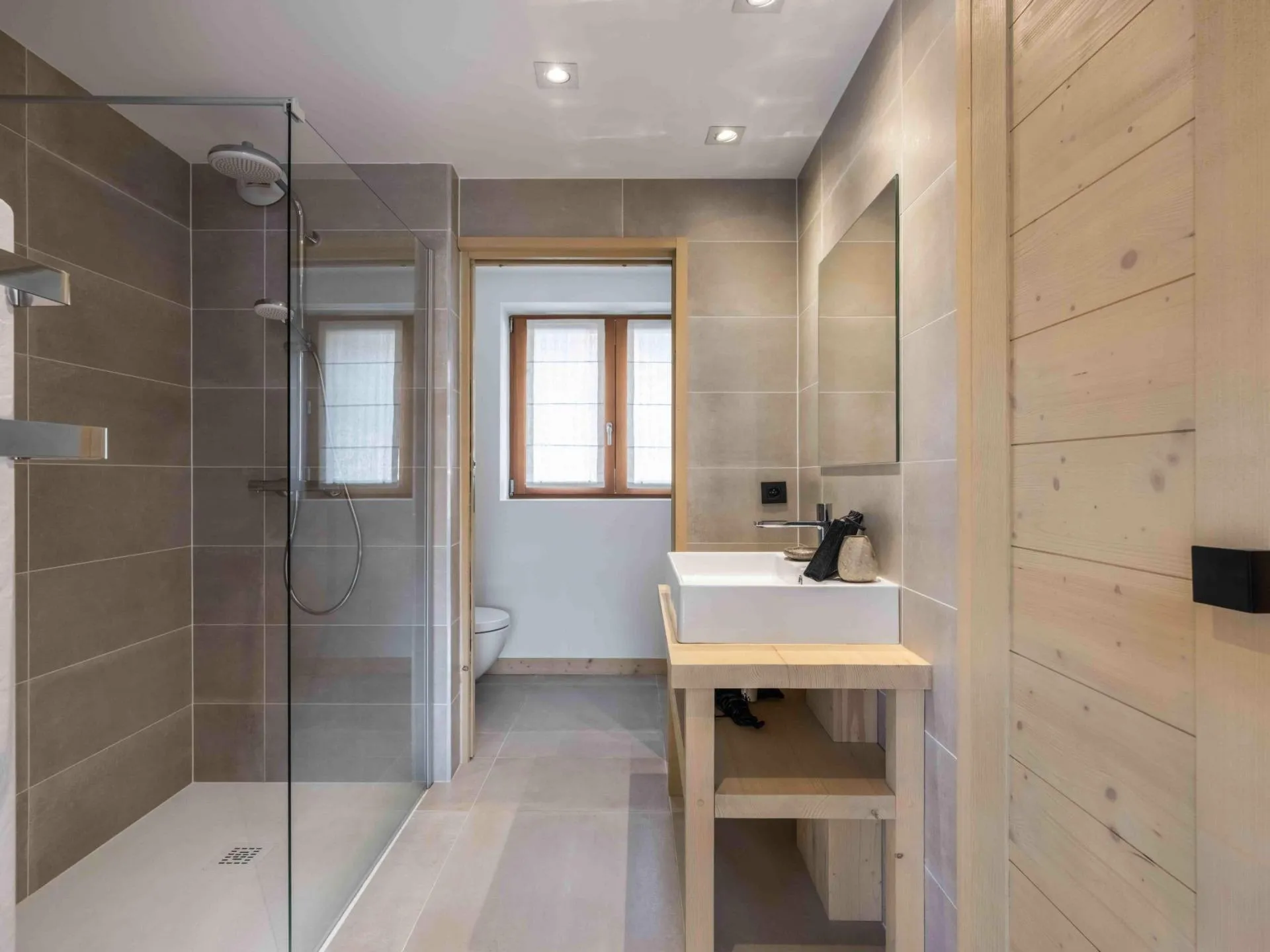 En-suite shower room with a vessel basin and heated towel rail