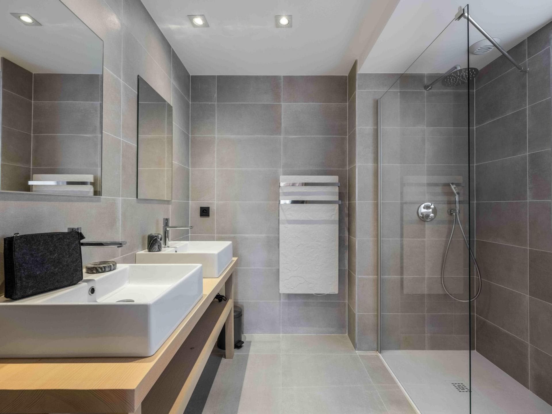 Bathroom with dual vanity, walk-in shower, and heated towel rack