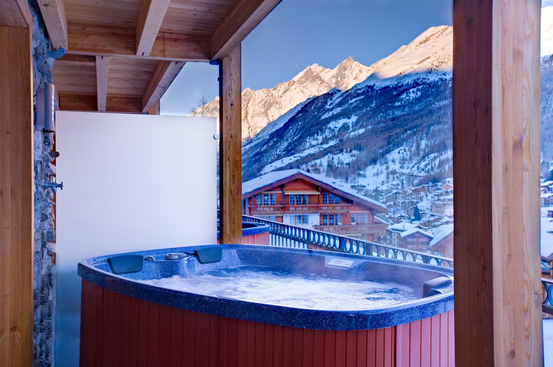 Covered balcony hot tub with privacy screen and mountain views