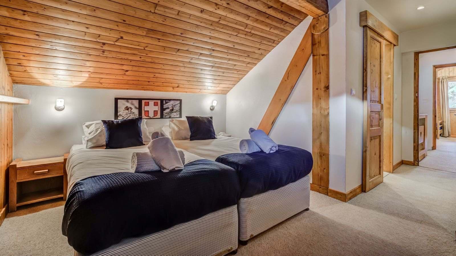 Attic bedroom with zip-and-link twin beds and vaulted wood ceiling
