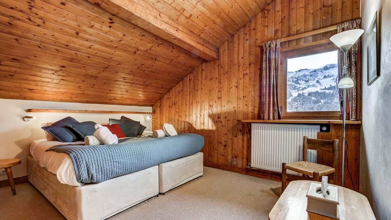 Wood-paneled bedroom with king bed and mountain views