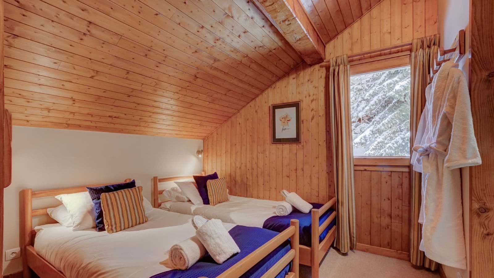 Guest bedroom with twin beds and wood-paneled vaulted ceilings