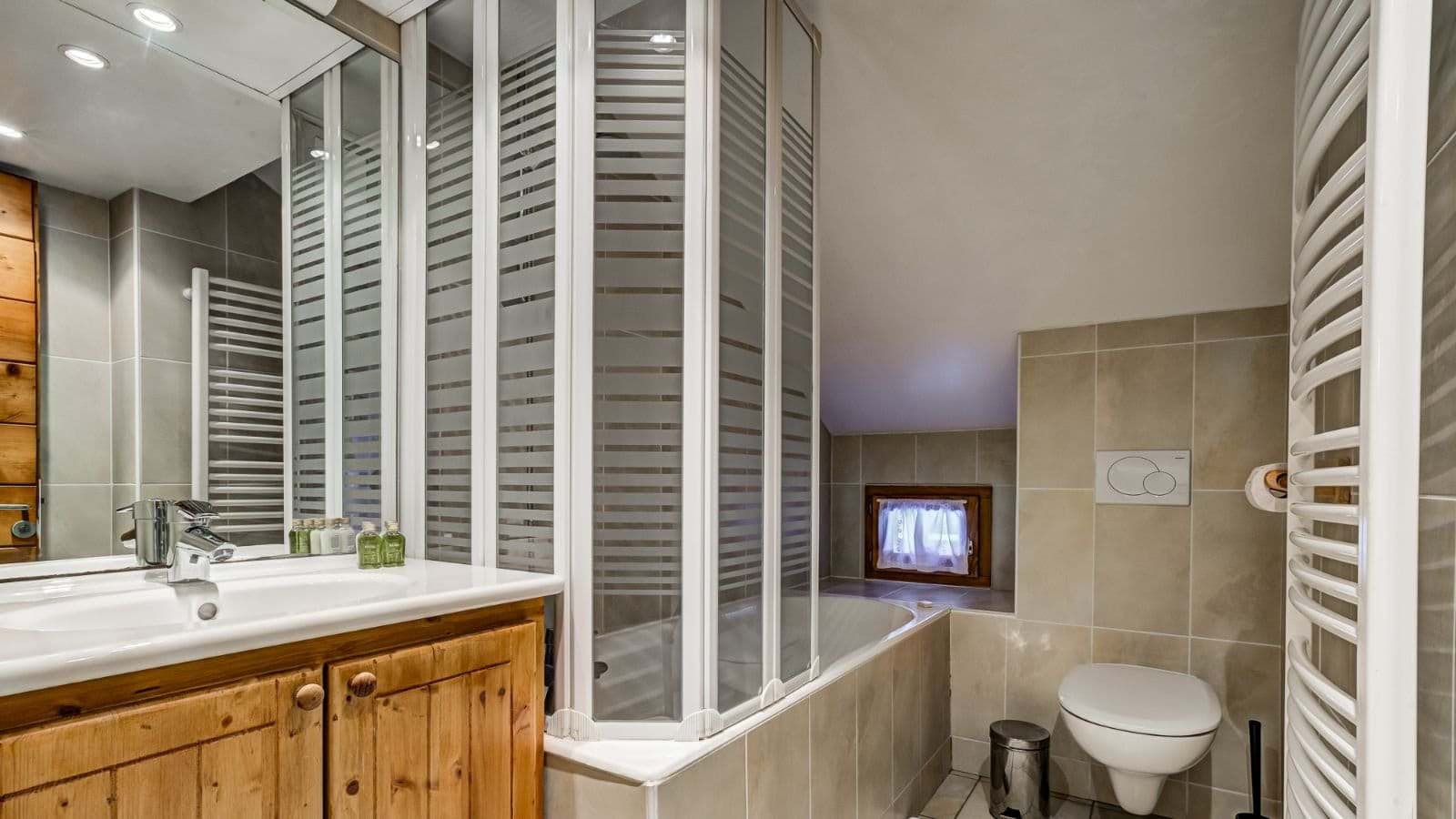 Bathroom with heated towel rail, soaking tub, and vanity