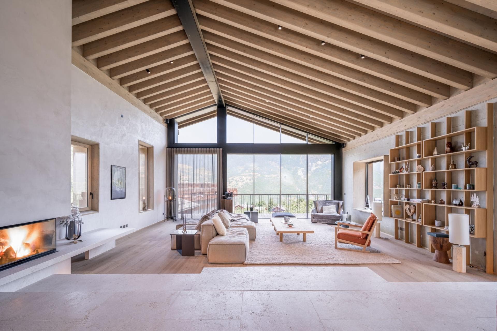 Living area with wood-burning fireplace and floor-to-ceiling mountain views