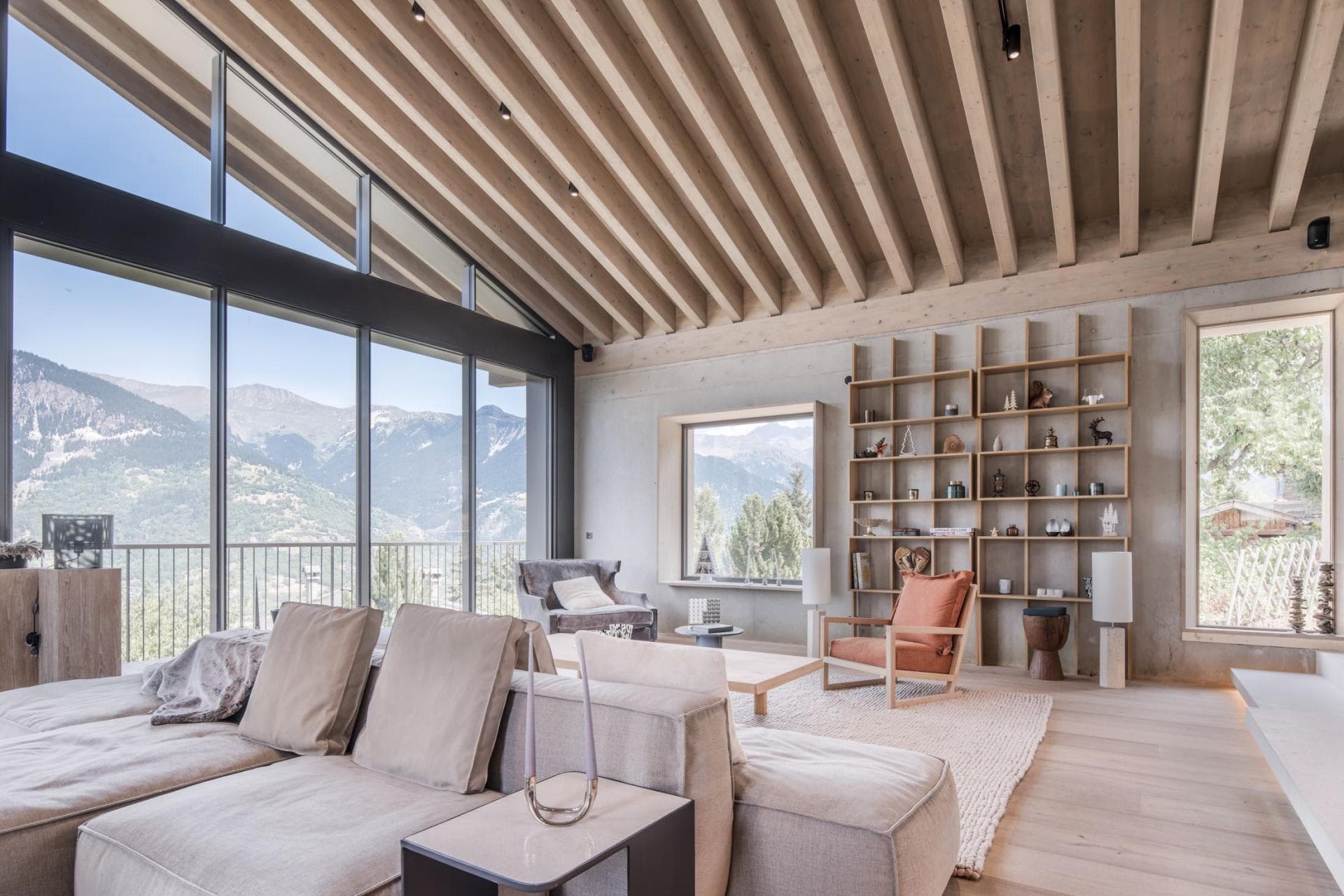 Living area with vaulted beam ceilings and mountain-view floor-to-ceiling windows