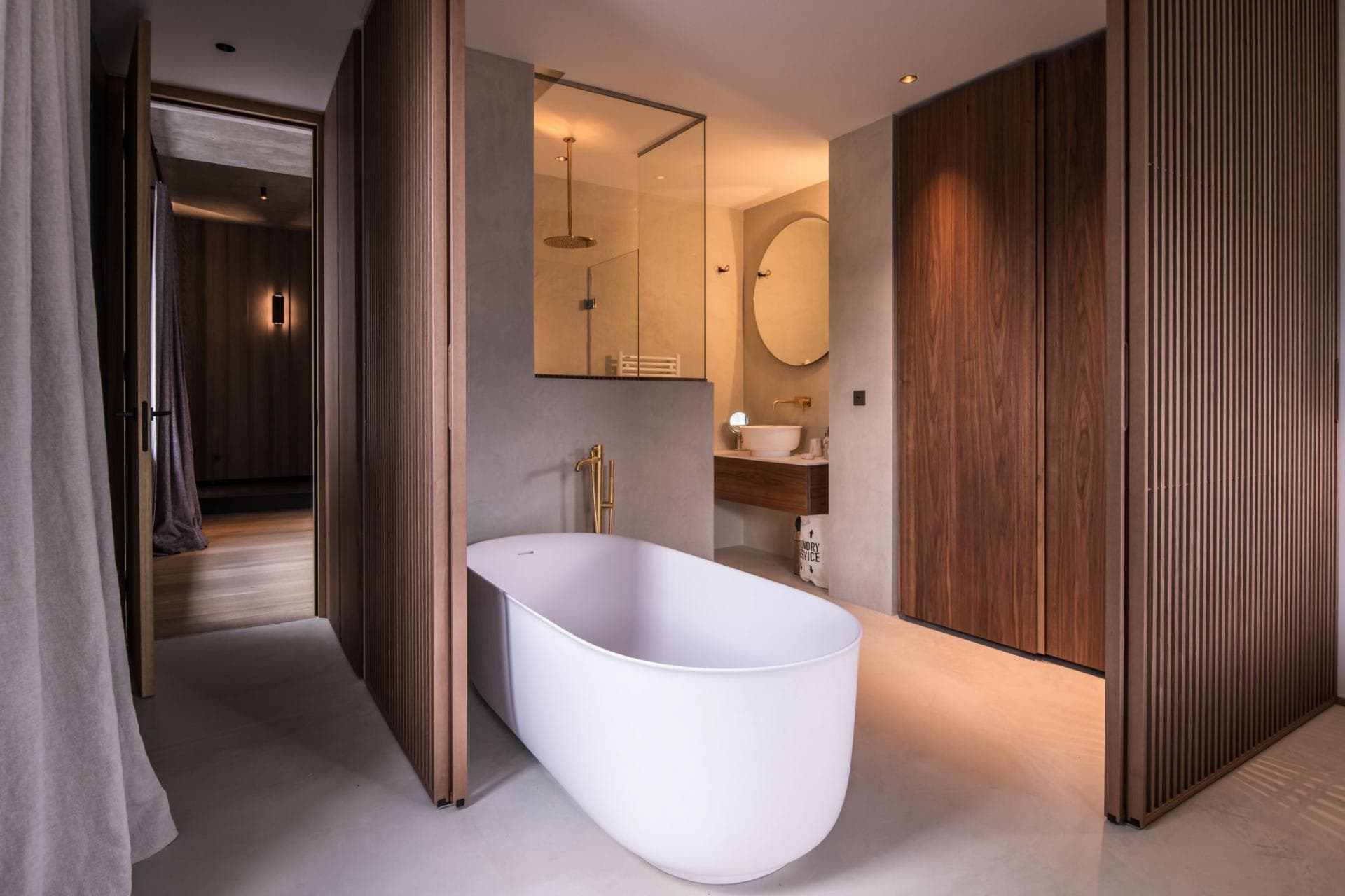 En suite bathroom with freestanding soaking tub and glass rain shower