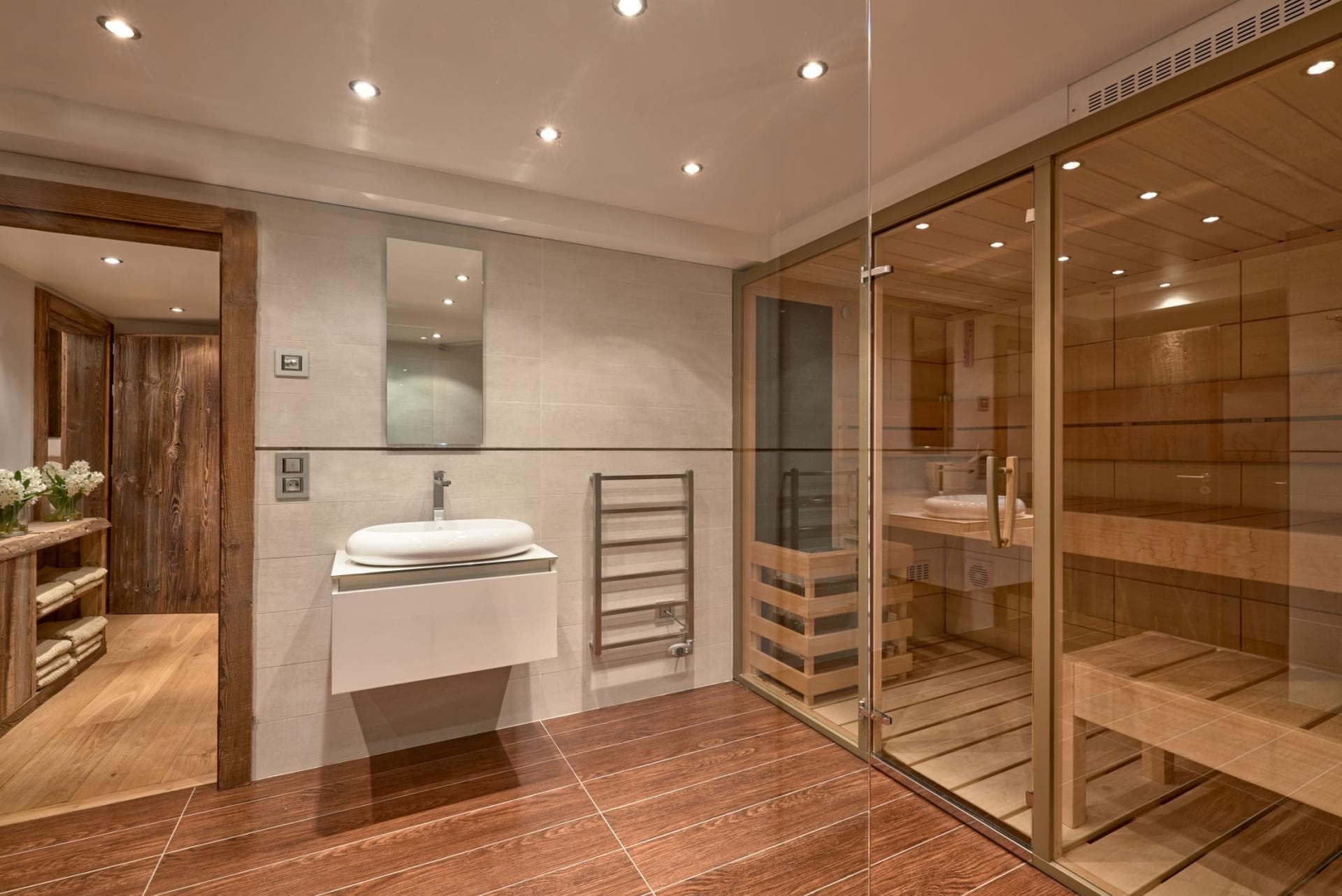 Sauna with glass enclosure and heated towel rack