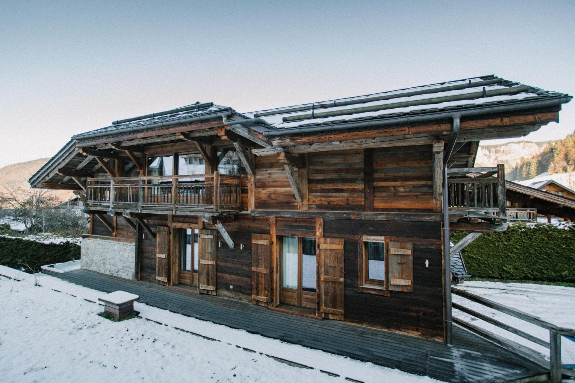 Two-story wood chalet with upper balconies and ground-floor deck access