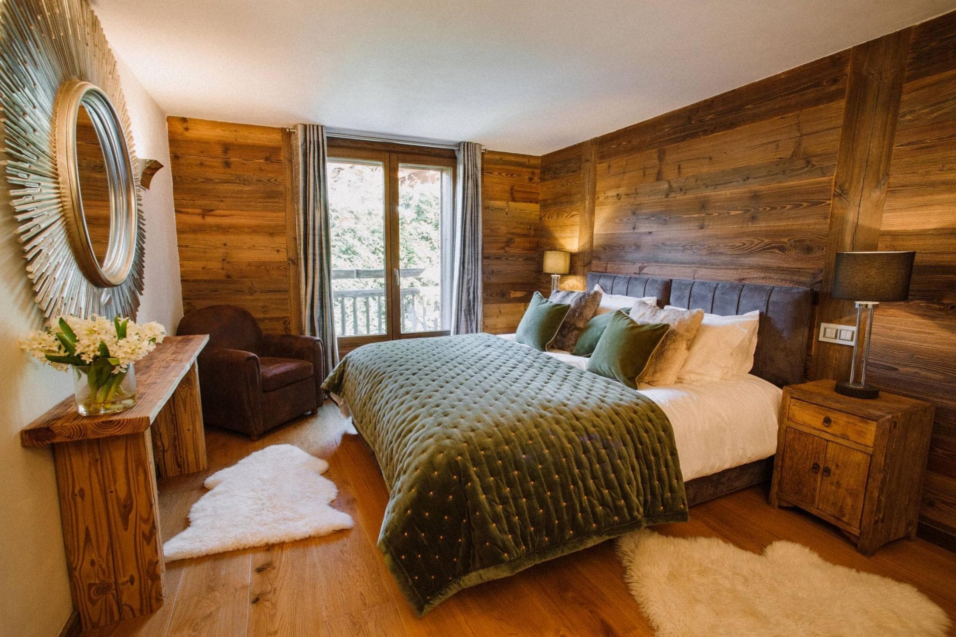 Wood-paneled bedroom with king bed and balcony access