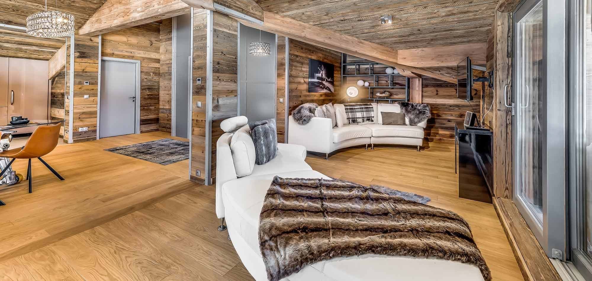 Upper floor lounge with curved sectional and wall-mounted smart TV