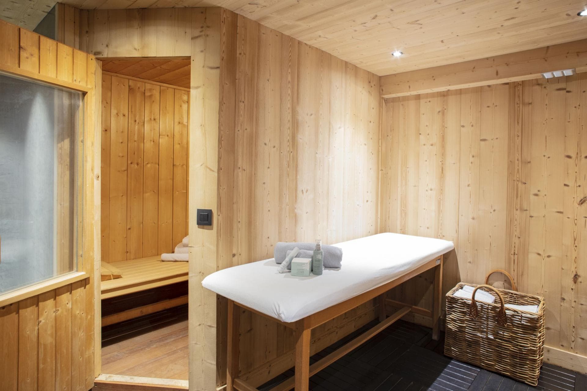 Spa room with massage table and adjacent private sauna
