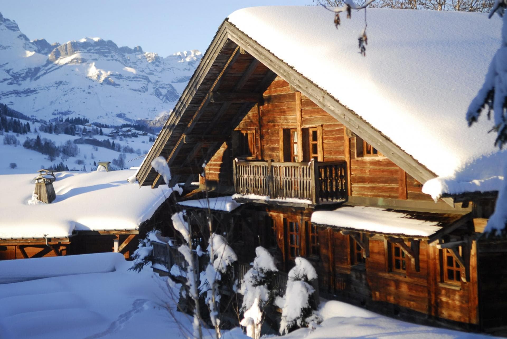 Wooden chalet exterior featuring private balconies and alpine mountain views