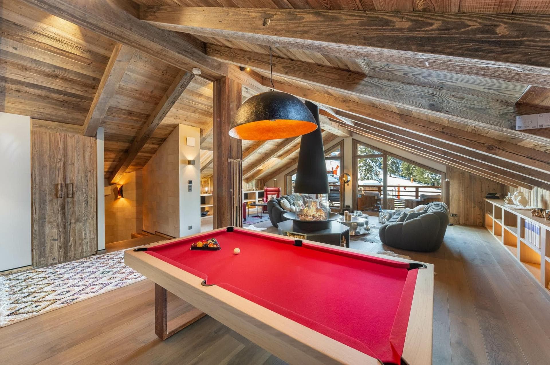 Loft game room with pool table and central hanging fireplace
