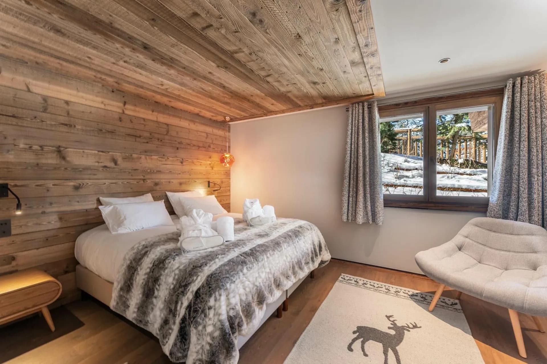 Double bedroom with a timber wall and lounge chair