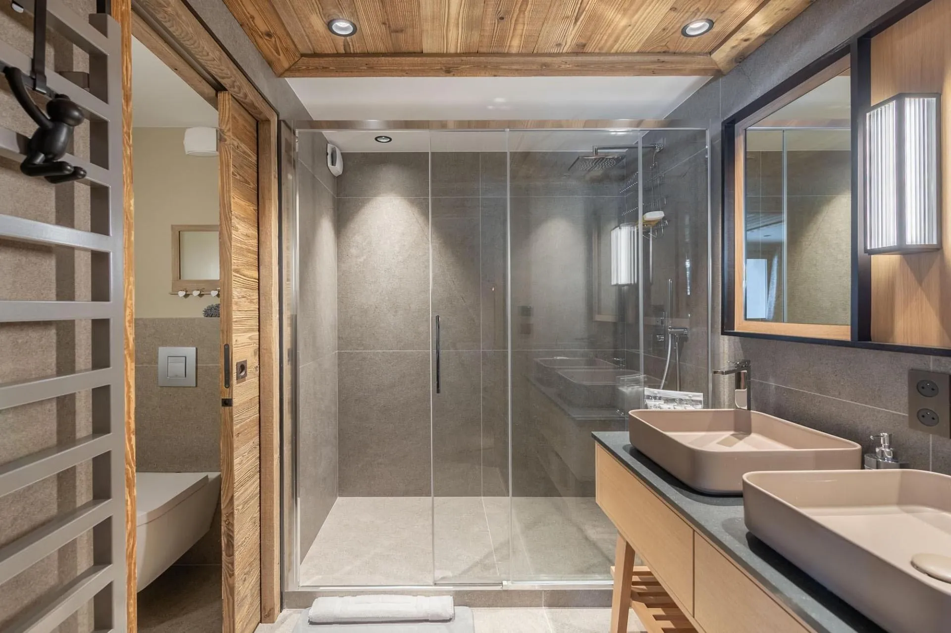 En-suite shower room with twin basins and a heated towel rail