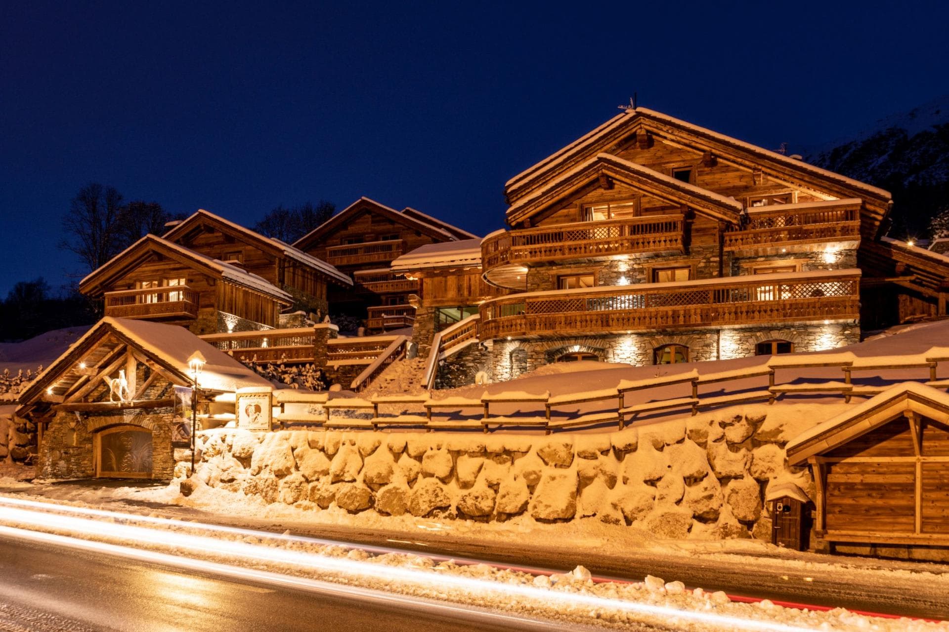 Chalet exterior at night with multiple private balconies and roadside access