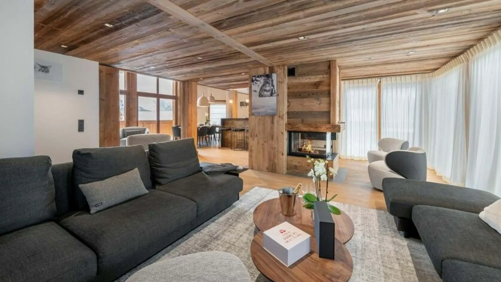 Living room with timber beams, a fireplace and sectional seating