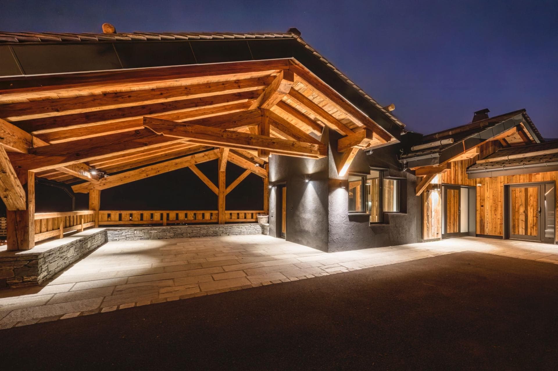 Covered timber entryway and stone patio with integrated night lighting