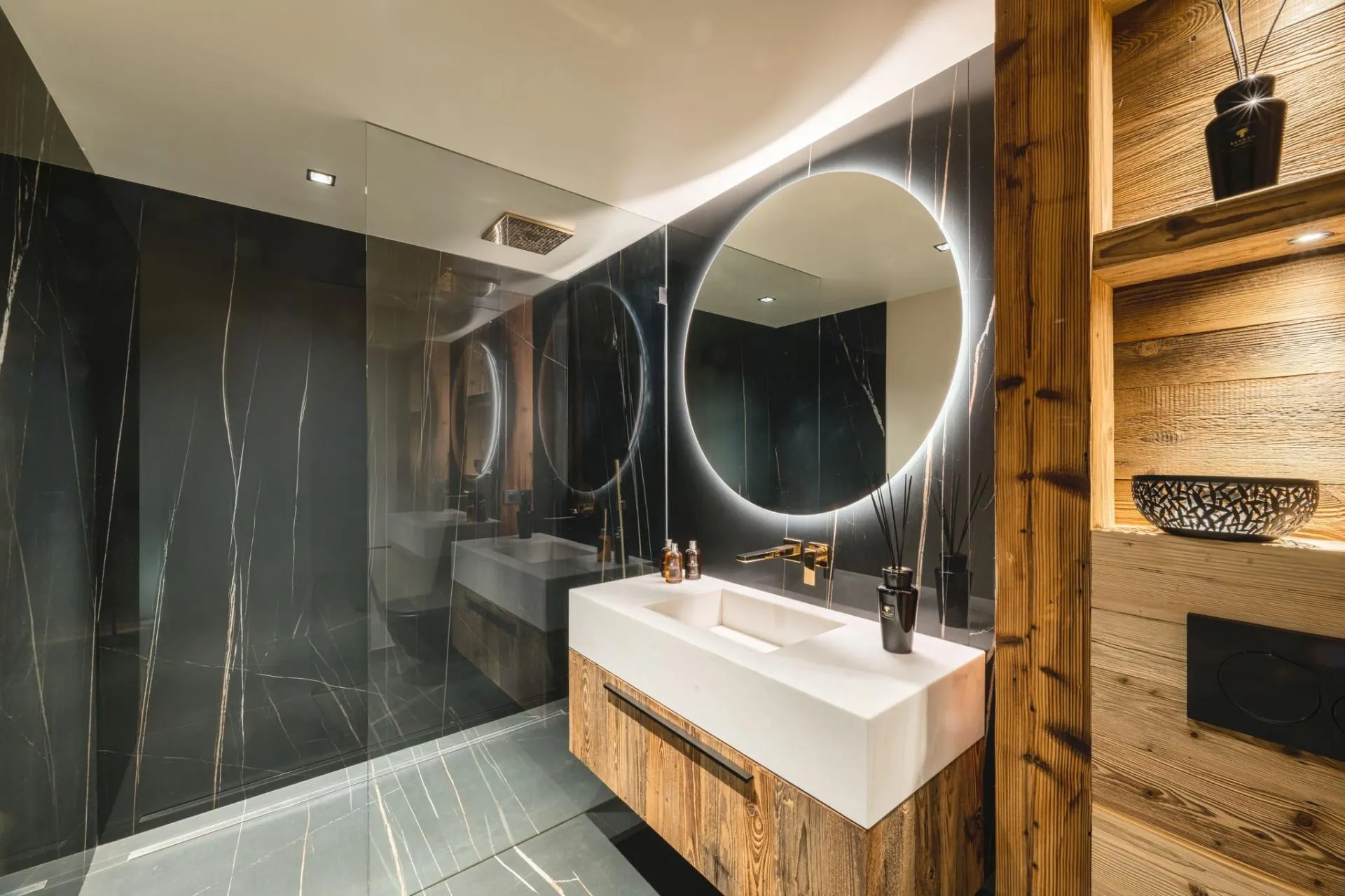 Bathroom featuring walk-in rainfall shower and backlit vanity mirror