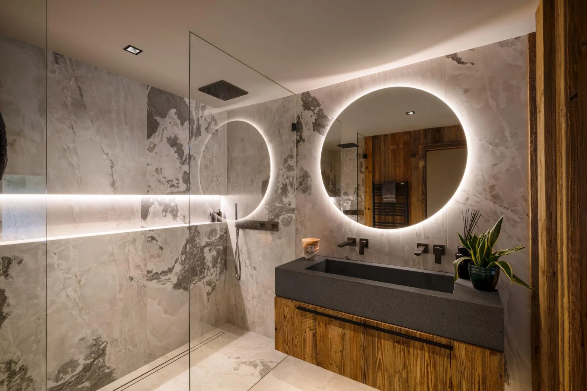 Bathroom featuring walk-in rainfall shower and backlit vanity mirror