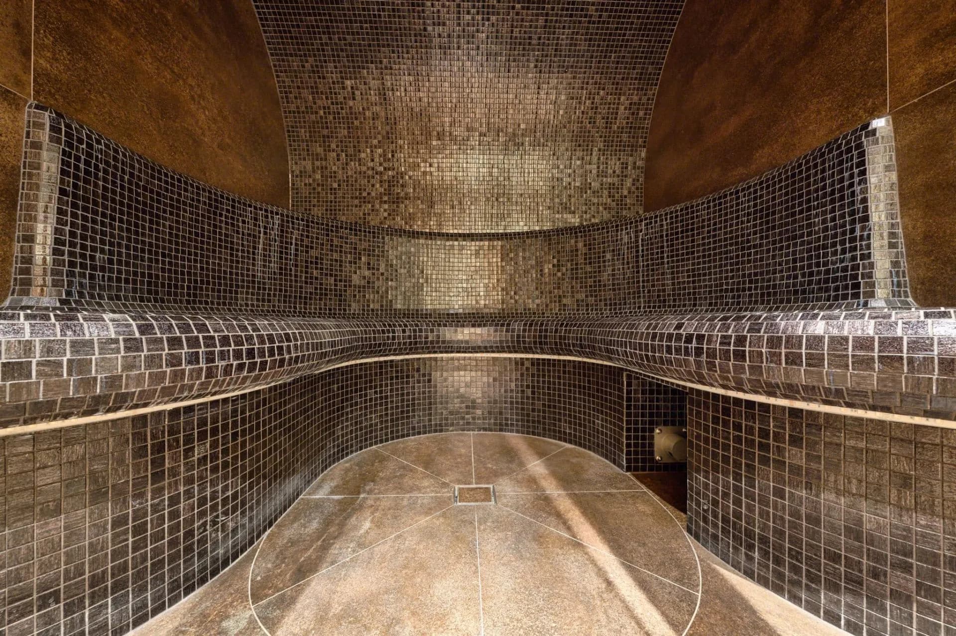 Mosaic-tiled hammam with a built-in bench