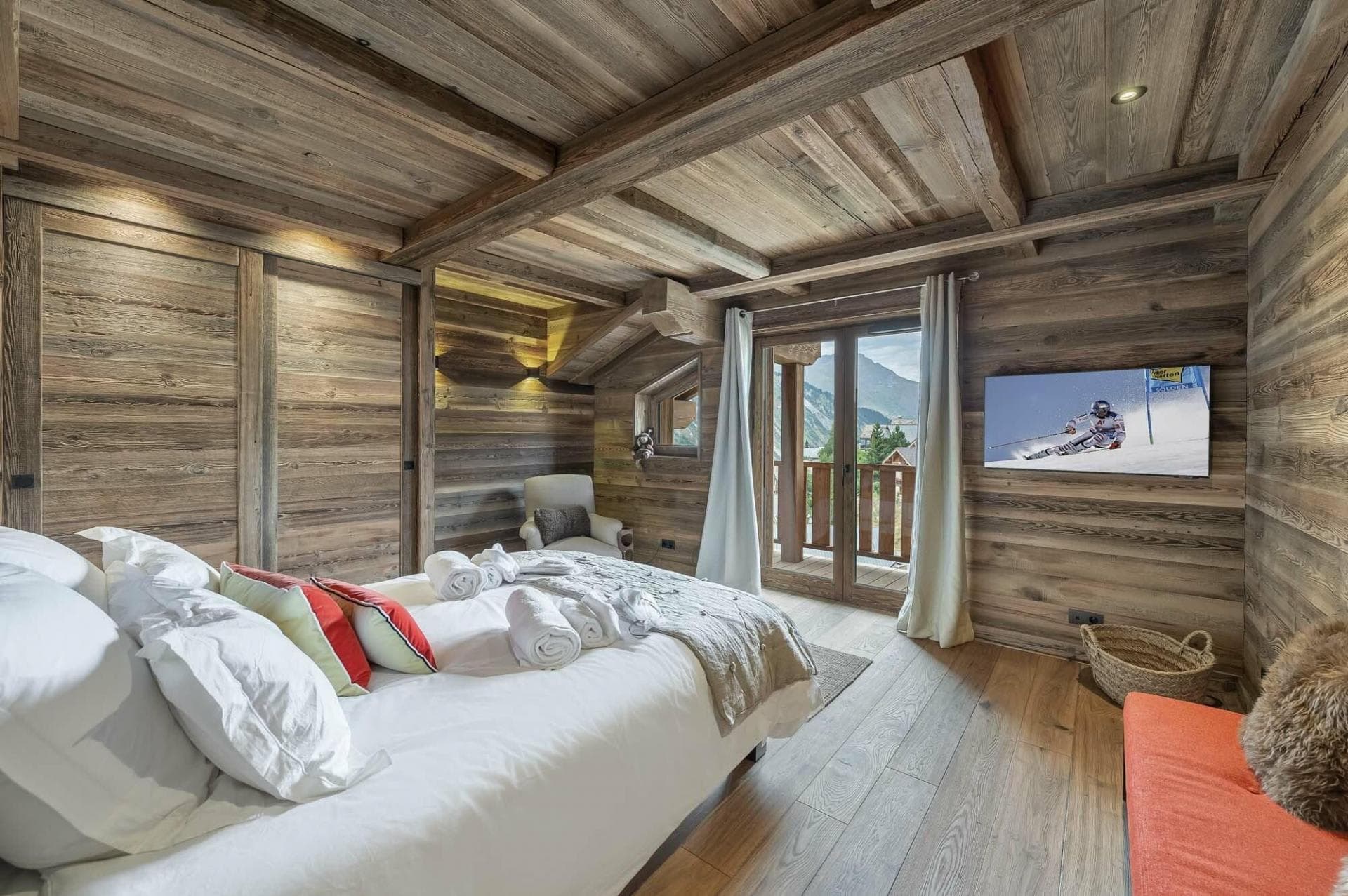 Wood-paneled bedroom with balcony access and mountain views