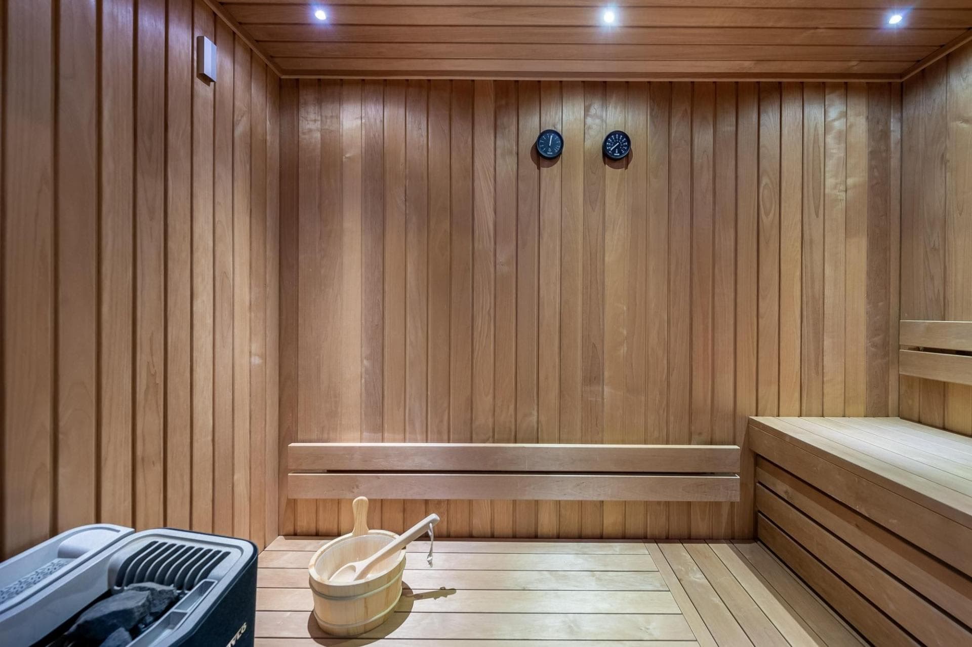 Private cedar sauna with tiered seating and electric heater